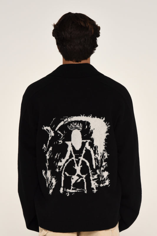 Man wearing a black cardigan with a white graphic design of a woman on the back 