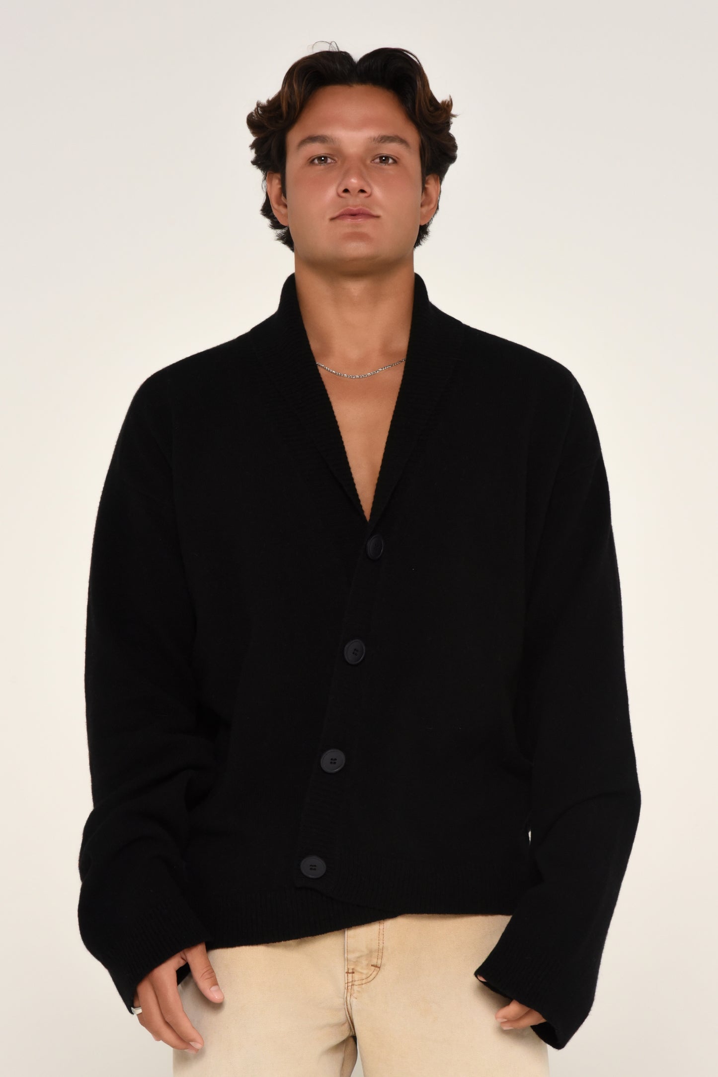 Man wearing an oversized black cardigan with buttons