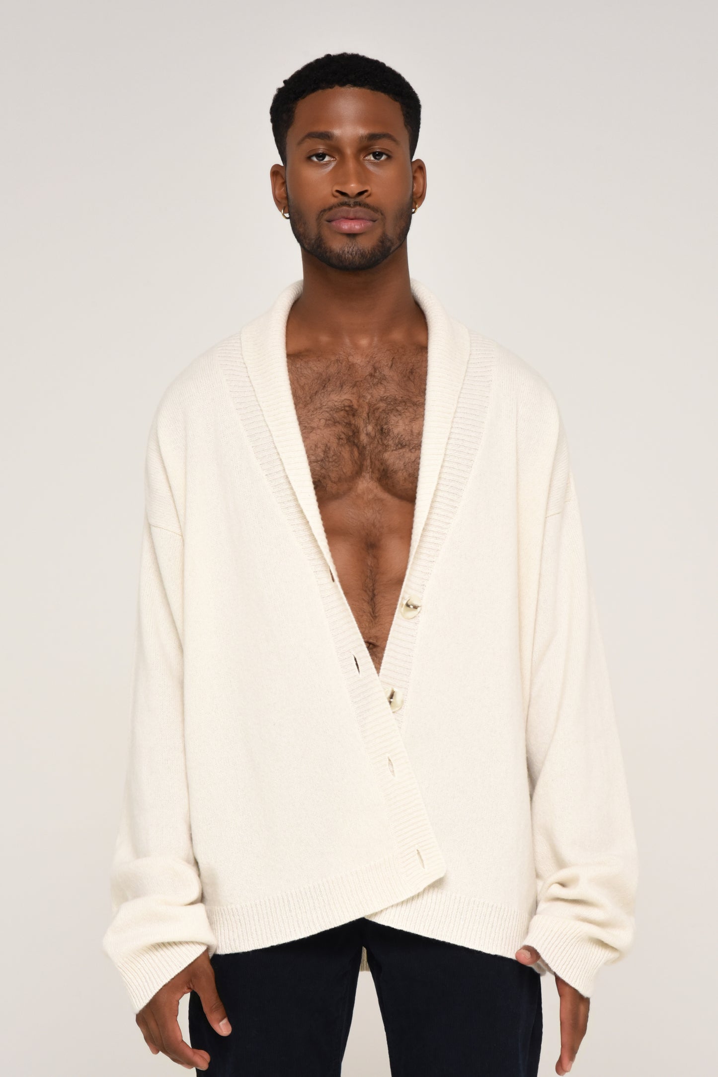 Man wearing an oversized cream cardigan with buttons