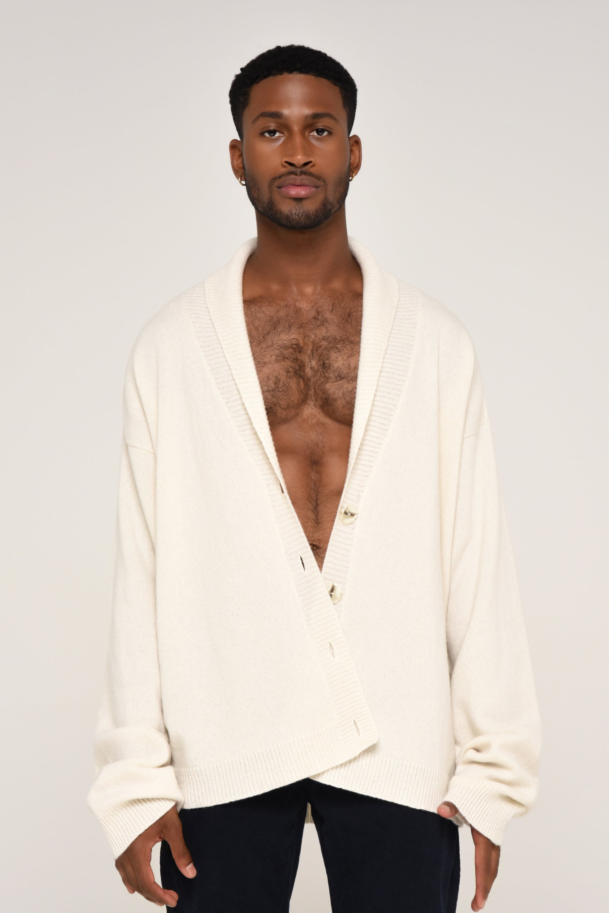 Man wearing an oversized cream cardigan with buttons