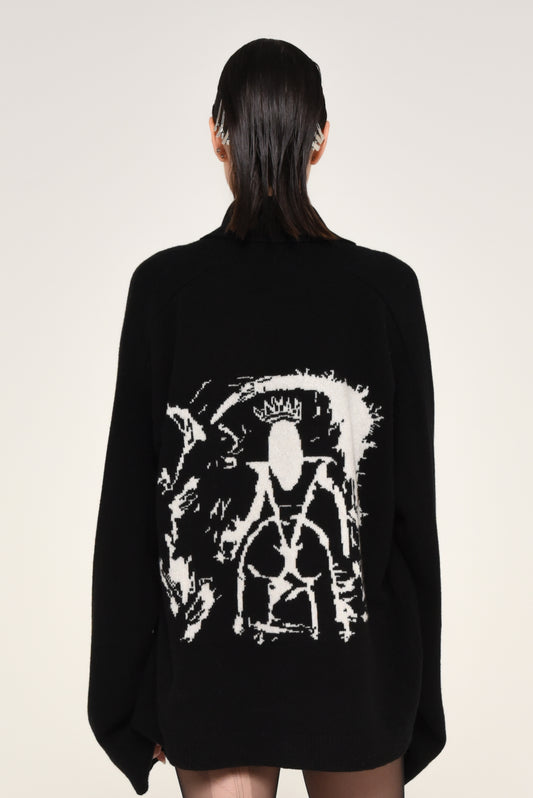 Back view of woman wearing a black cardigan with a white graphic design of a woman on the back 