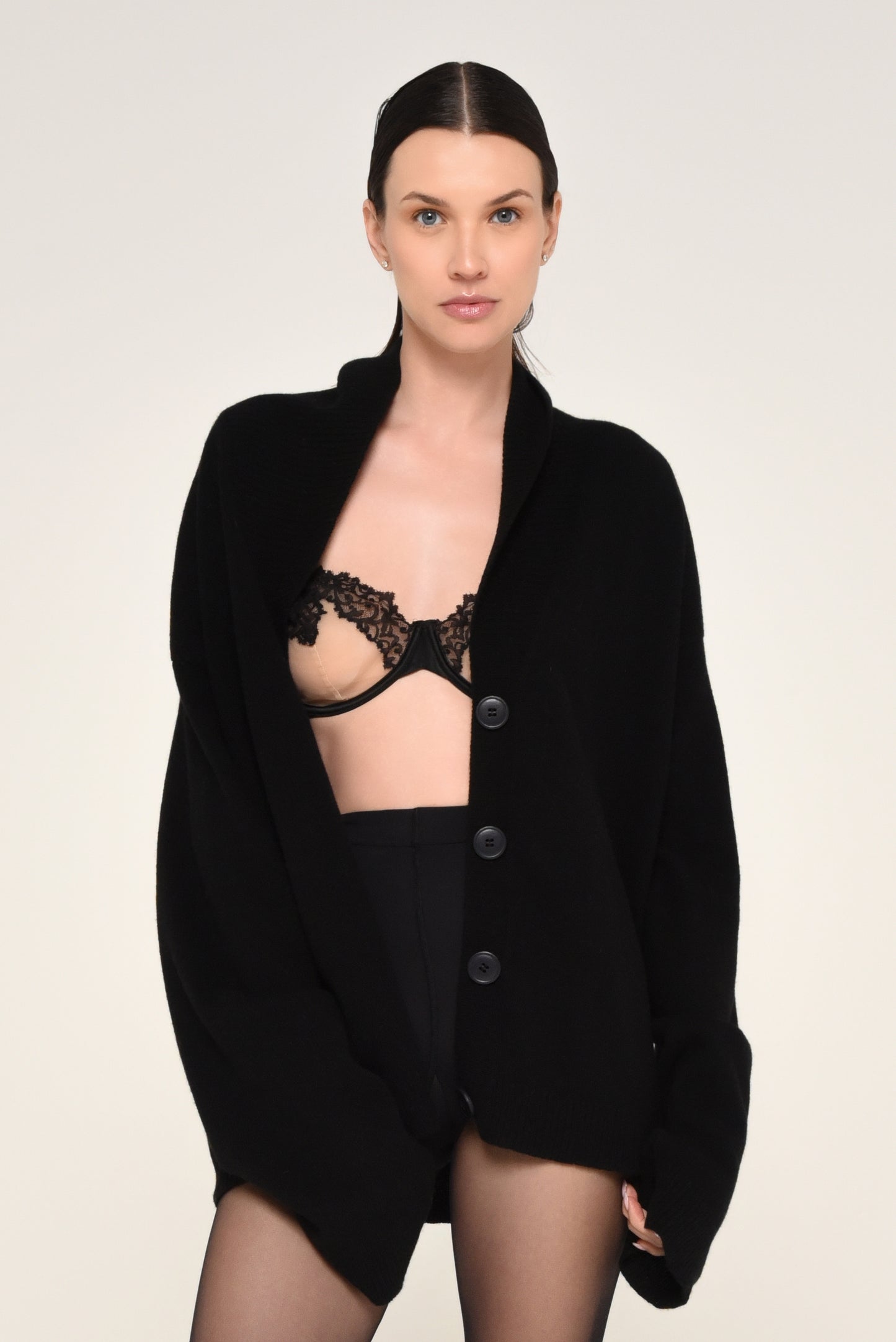 Woman wearing an oversized black cardigan with buttons