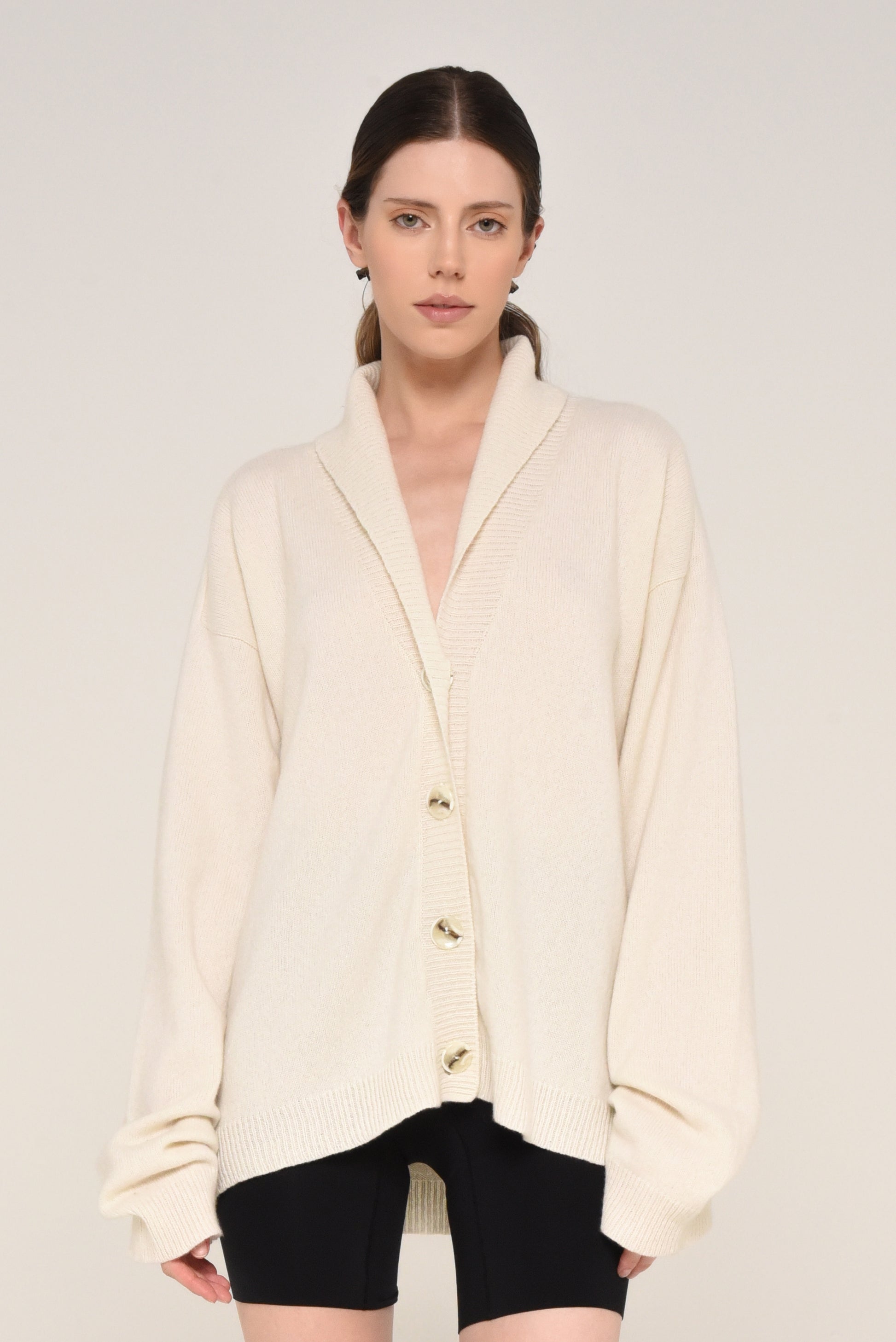 Woman wearing an oversized cream cardigan with buttons
