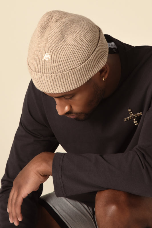 Man wearing a nude knit beanie with embroidery