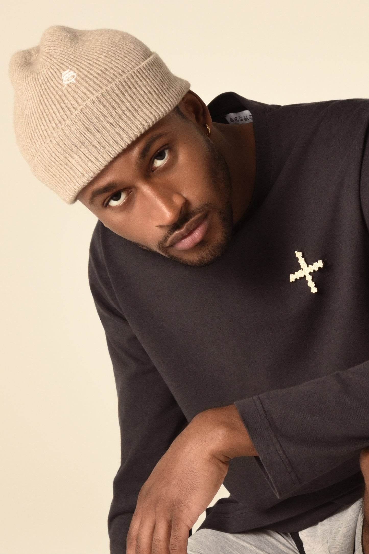 Man wearing a nude beanie with embroidery detail