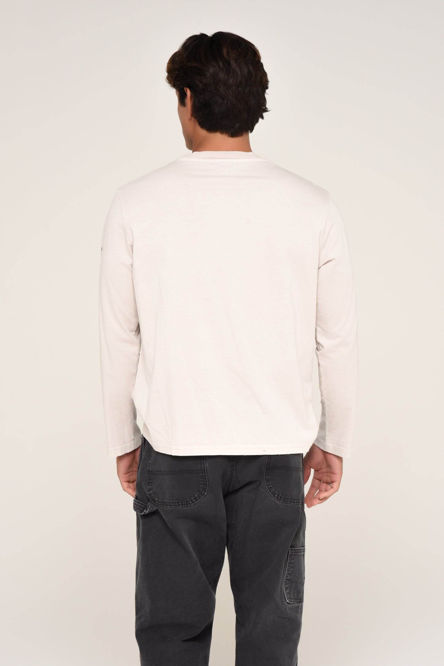 Back view of man wearing an off-white long sleeve shirt