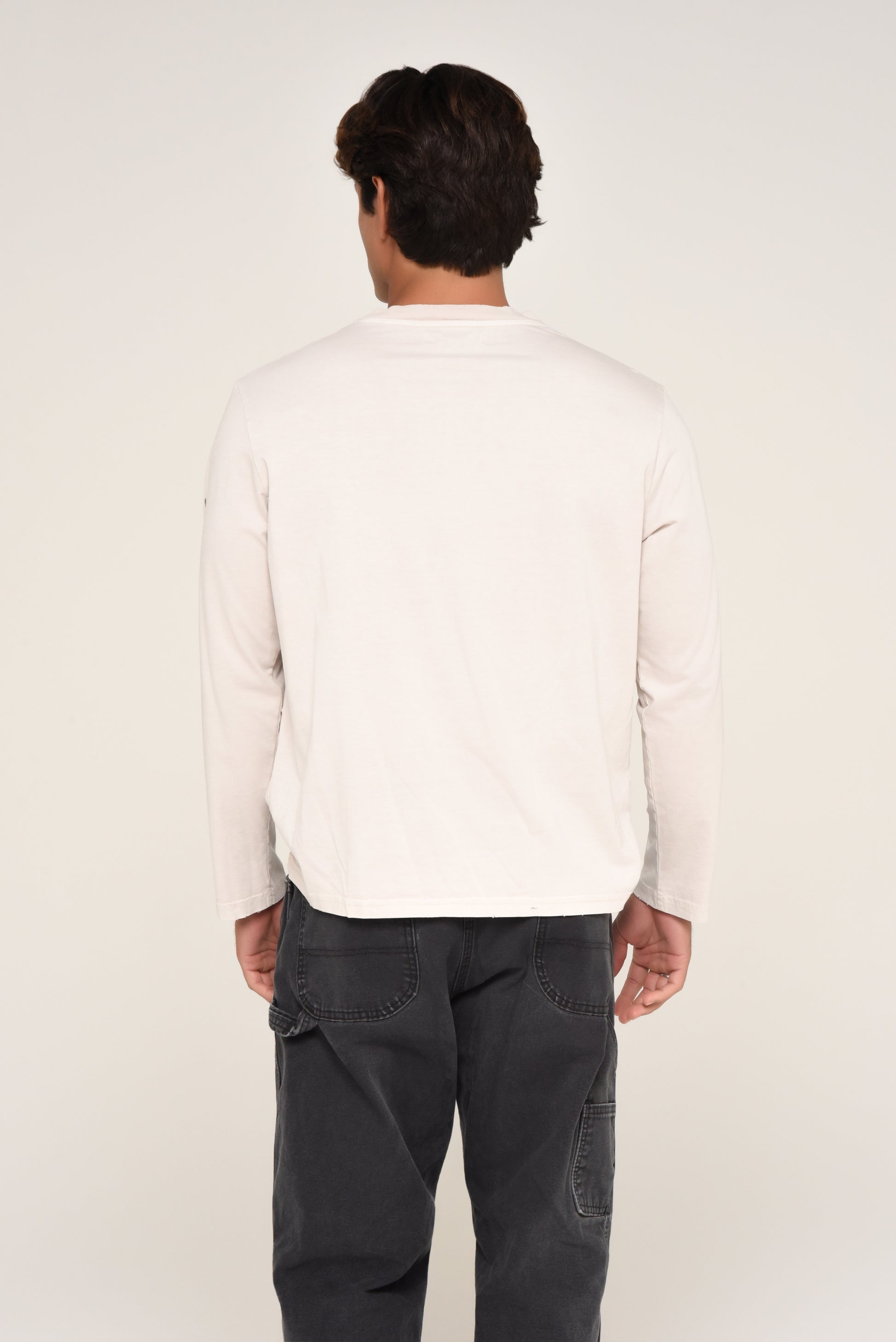 Back view of man wearing an off-white long sleeve shirt
