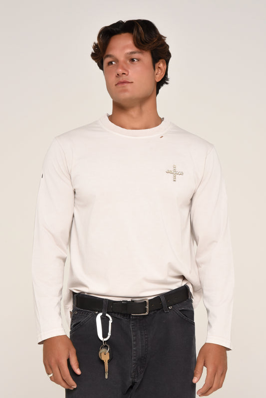 Man wearing an off-white long sleeve shirt with embroidered cross detail, styled as a neutral streetwear look.