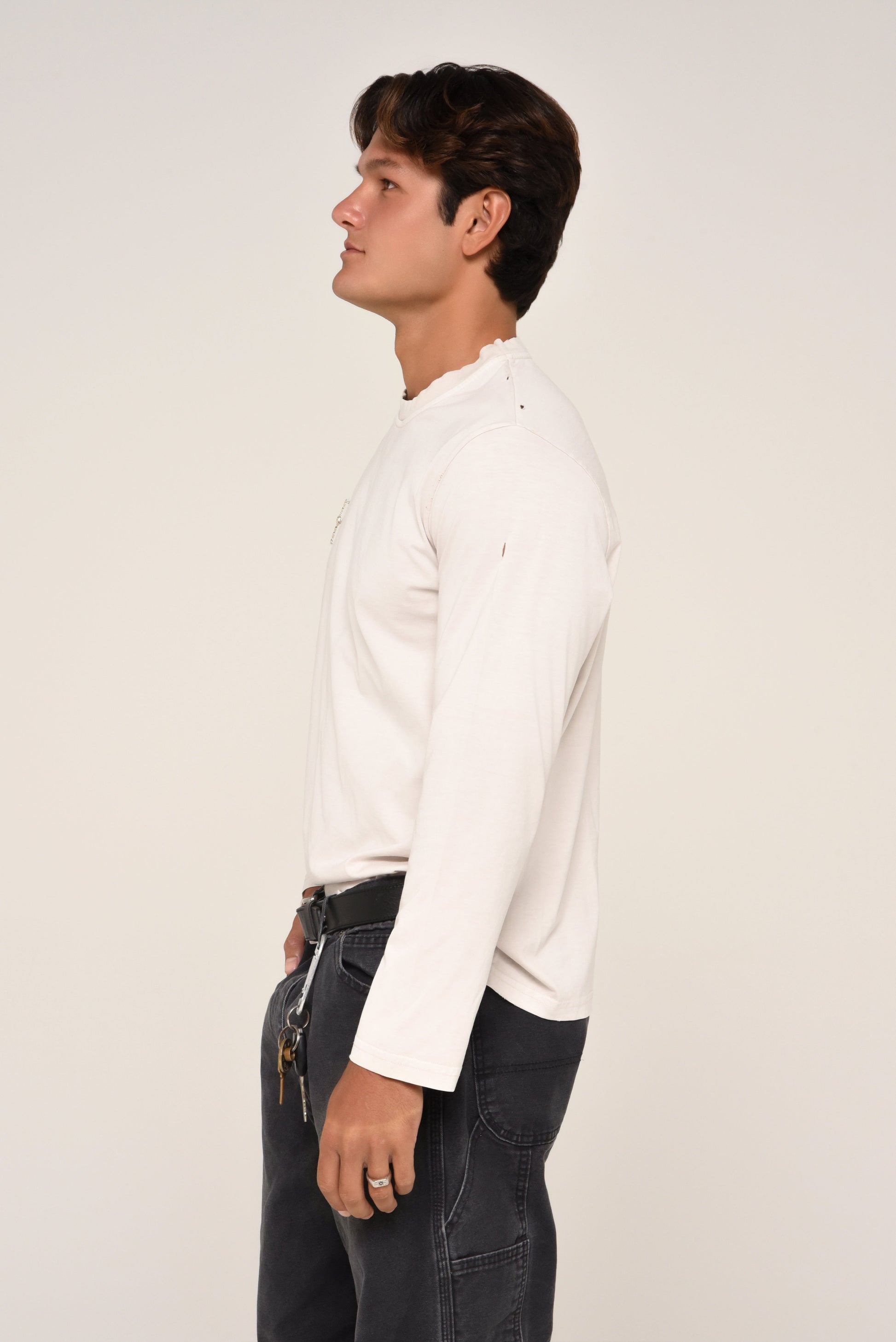 side view of man wearing an off-white long sleeve 
