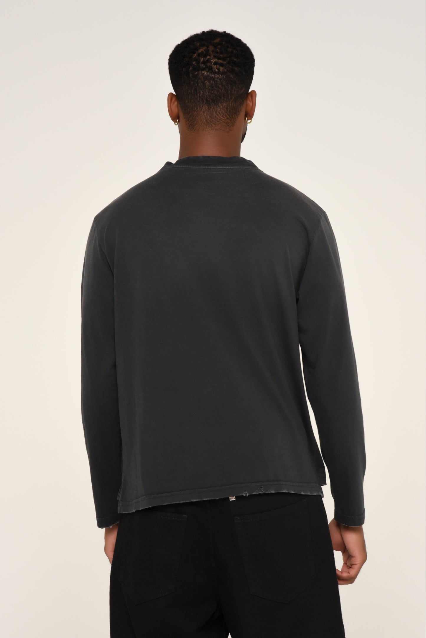 back view of man wearing a black long sleeve shirt