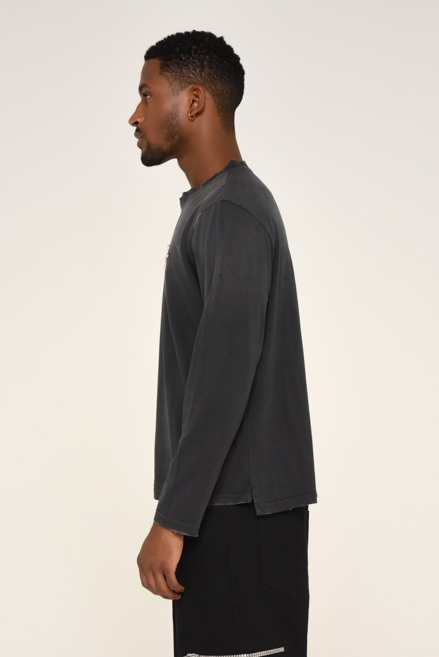 side view of man wearing a black long sleeve shirt