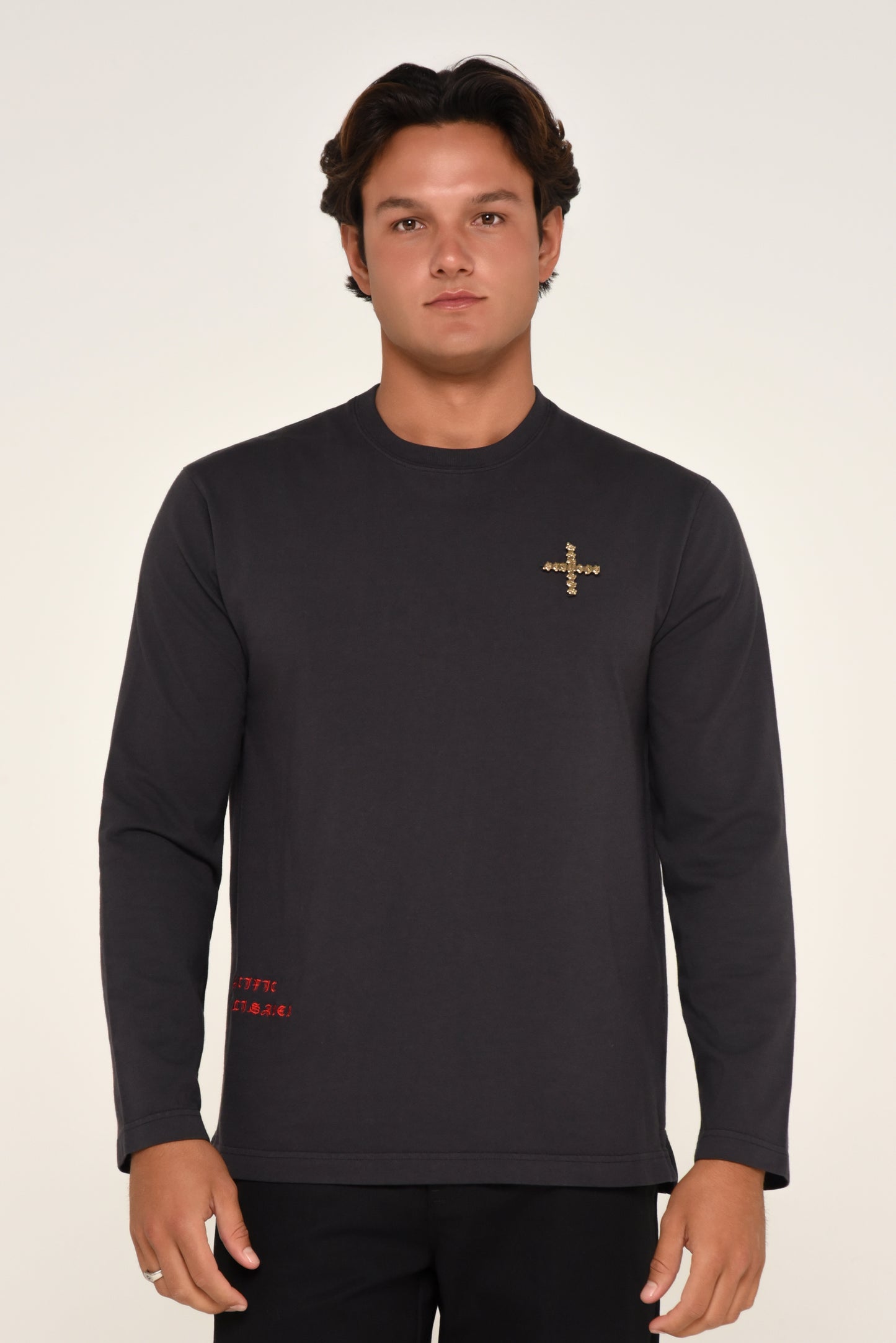 Man wearing a black long-sleeve shirt with cross detail and red text