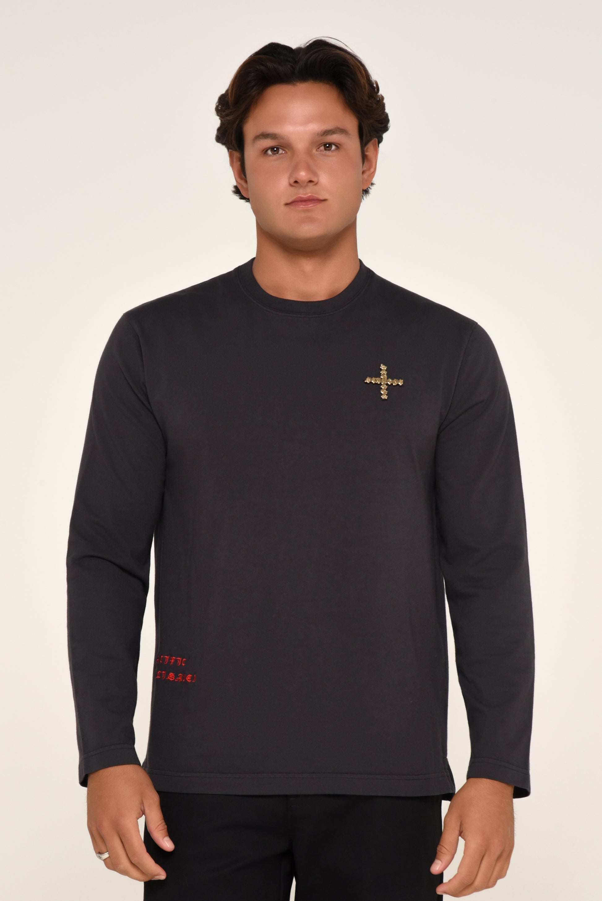 Man wearing a black long-sleeve shirt with cross detail and red text